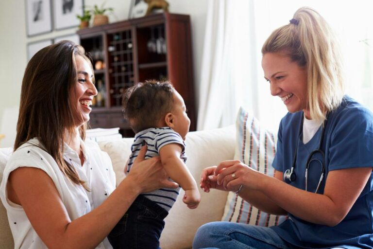 Two moms talking and playing with baby. ,l
